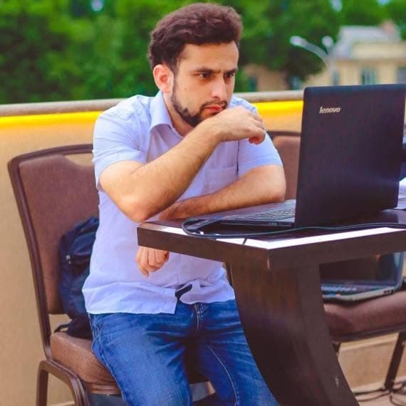 Dodikhudo Abdurahimov working on a laptop, 2014
